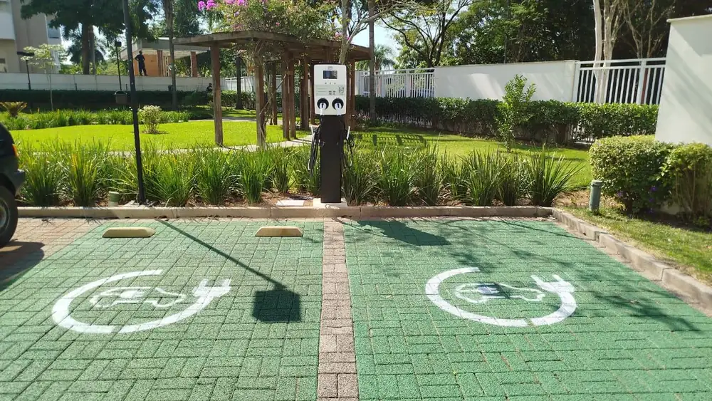 Estação de recarga dupla PowerUp em área ajardinada de condomínio