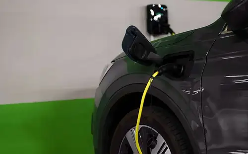 Cabo de recarga elétrica conectado a veículo em garagem de condomínio