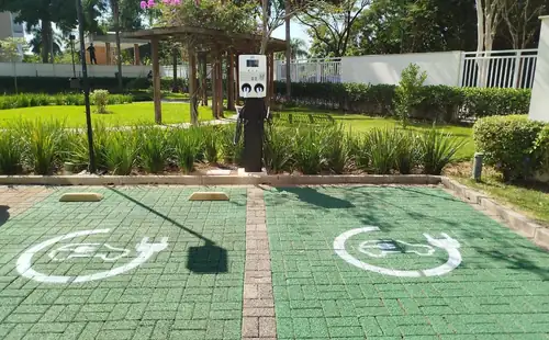 Estação de recarga dupla PowerUp em área ajardinada de condomínio